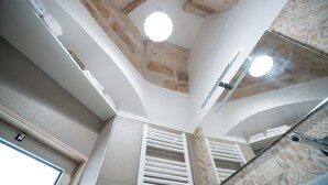 A bathroom with a stone ceiling, a mirror, and a towel rack. - Mest Michè by Polignando (Polignano a Mare)