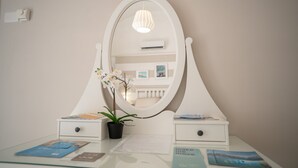 A vanity with a white oval mirror, a potted orchid, and two bedside tables with drawers. - Mest Michè by Polignando (Polignano a Mare)