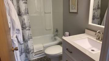 A bathroom with a bathtub, toilet, and sink.