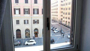 A view from a window of a street with parked cars and buildings. - Eden Luxury Suites (Rome)