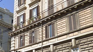 A multi-story building with a stone facade, a central entrance with a decorative arch, and a ground-level storefront with a sign that reads "EDAS". - Eden Luxury Suites (Rome)