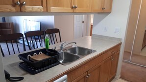 A kitchen with wooden cabinets, a dishwasher, a sink, and a toaster.
