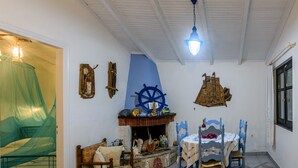 Una habitació amb un llit, una taula, cadires, una llar de foc i una finestra.