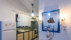 Una cuina compacta amb nevera, rentaplat i armaris.
