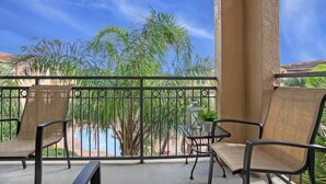 Ein Balkon mit zwei Stühlen, einem Tisch und einem Blumentopf.
