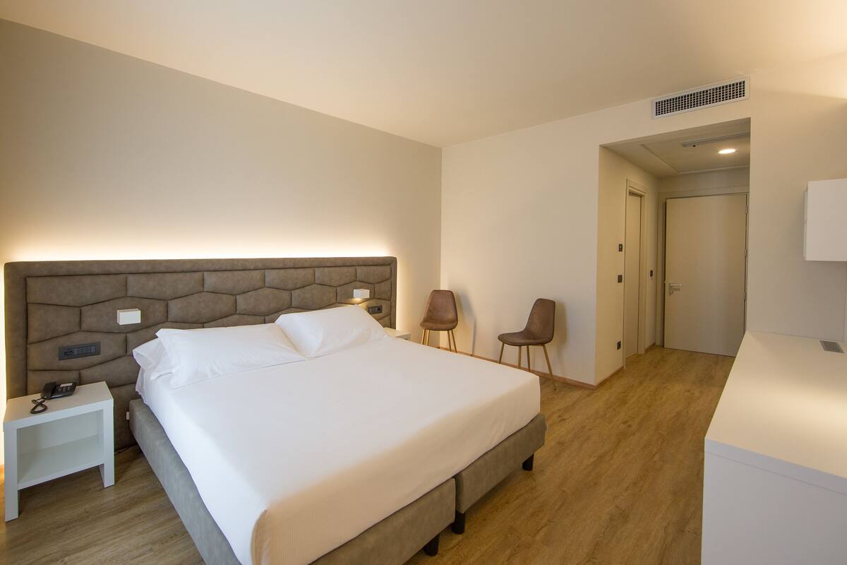Minibar, desk, laptop workspace, bed sheets