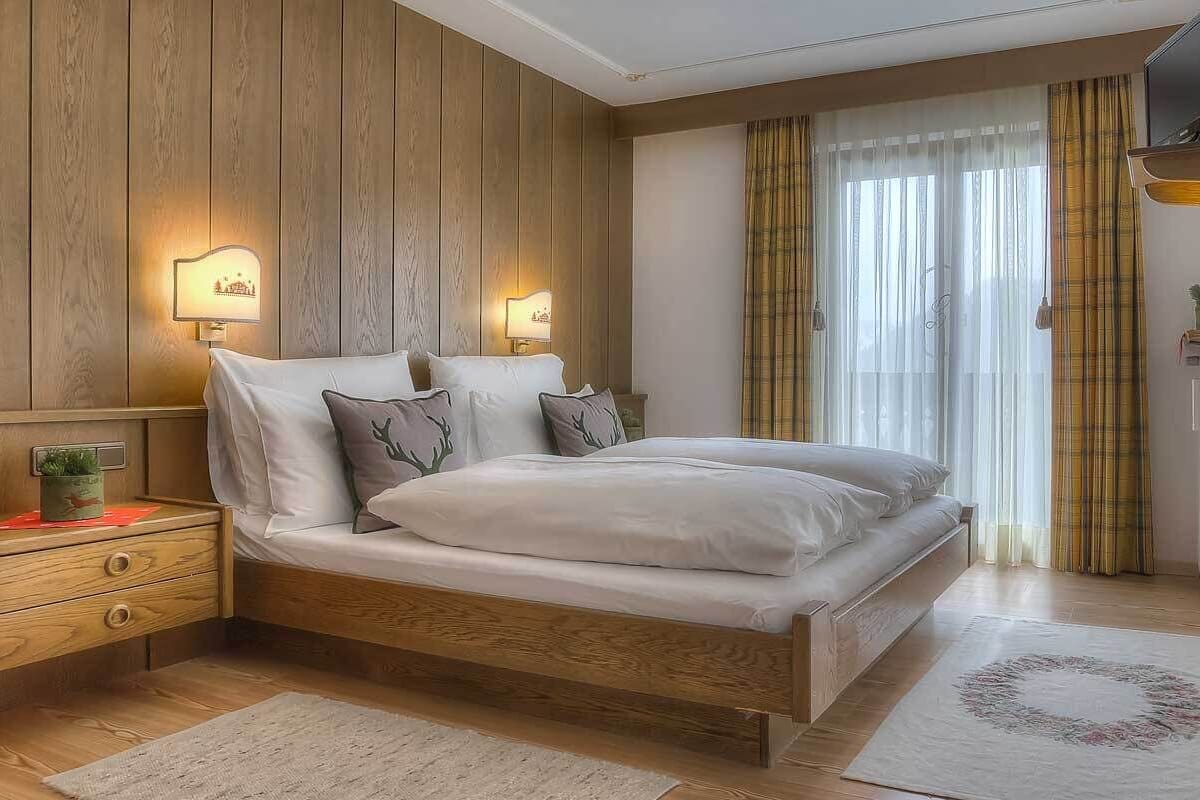 Une chambre à coucher avec un lit en bois, des tables de chevet et des lampes fixées au mur.
