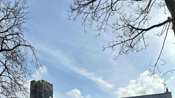 A two-story building with a stone tower, a sign reading "Lambrook Inn," and a well-maintained garden with a picnic table. - OYO Lamphey Hall Hotel (Pembroke)