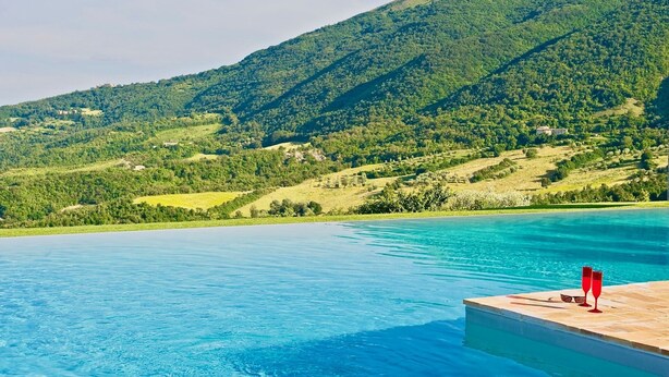 A pool with a wooden deck and a view of a mountainous landscape. - BELLAVISTA - Three Bedroom Villa, Sleeps 8 (Perugia)