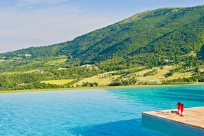 A pool with a wooden deck and a view of a mountainous landscape. - BELLAVISTA - Three Bedroom Villa, Sleeps 8 (Perugia)