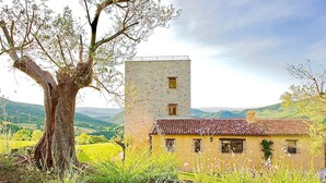 A rustic building with a tower and a tree in the foreground. - BELLAVISTA - Three Bedroom Villa, Sleeps 8 (Perugia)