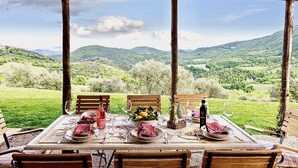 An outdoor dining area with a table set for two, overlooking a mountainous landscape. - BELLAVISTA - Three Bedroom Villa, Sleeps 8 (Perugia)