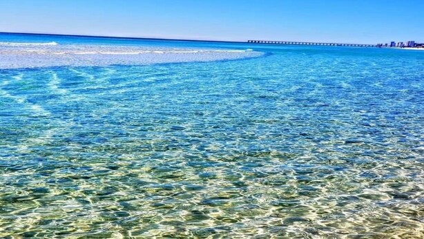 A clear view of a beach with a pier extending into the ocean. - # 505~BeachFront 5th Floor Movie Theater~ Pools ~ Game Rm~ Majestic Beach Resort (Panama City Beach)