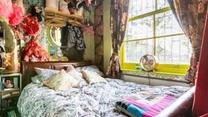 A bedroom with a bed, a window with curtains, a fan, and various items on shelves. - Boutique bijoux garden flat in vibrant Oval (London)