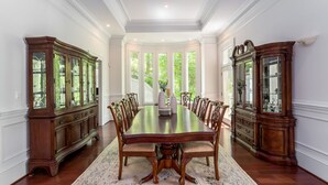 A formal dining room with a large wooden table, matching chairs, and two wooden sideboards. - Wedding Venue - Maison D'artagnan on Pimmit Run - Great for Extended Stays (McLean)