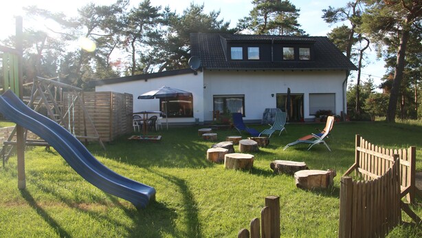A house with a slide, wooden deck, and outdoor seating area. - Vacation apartment "Eselstube"! Vacation on a farm in the Eifel (Nettersheim)