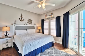 A bedroom with a bed, nightstands, a ceiling fan, a window with curtains, and nautical decor. - PierWatch II 309 | Second-Row Six Bedroom Condo (North Myrtle Beach)