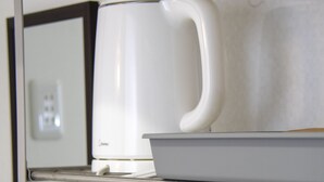 A kitchen area with a coffee maker, a kettle, and two mugs on a shelf. - Grande Shagi GS206 (Osaka)