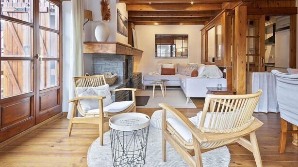 A cozy living room with a fireplace, wooden furniture, and large windows. - Luderna - Apartamento con terraza Orri A3 (Gessa)