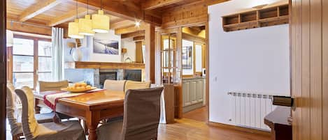 A wooden interior with a dining area, kitchen, and a view of the outdoors.