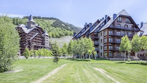Et hotel med flere etager, altaner og et bjerglandskab i baggrunden.