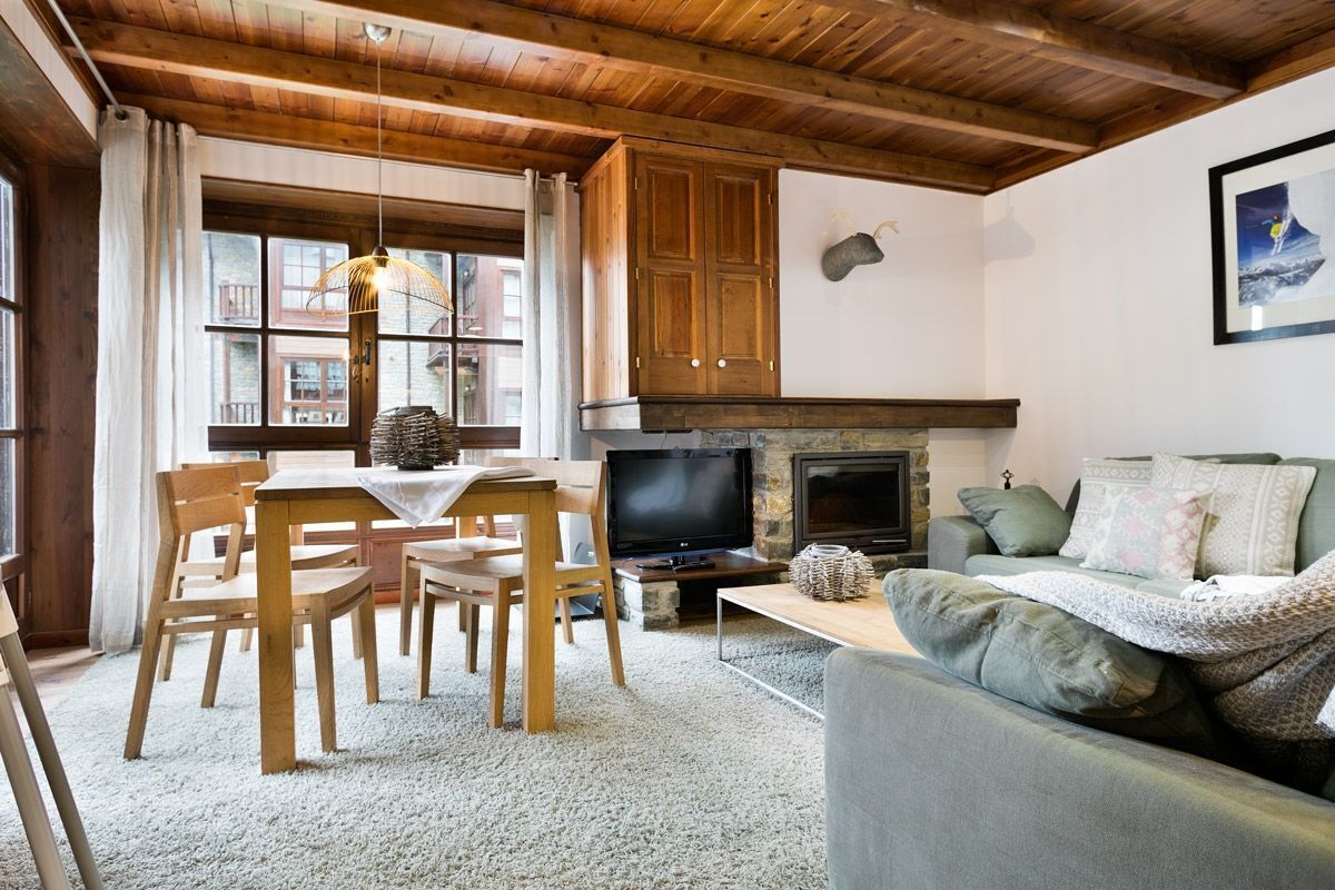 Una sala de estar acogedora con chimenea, muebles de madera y un televisor.