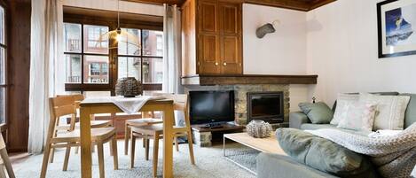 Una sala de estar acogedora con chimenea, muebles de madera y un televisor.