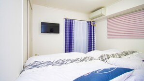 A hotel room with a bed, a television, and a window with curtains. - Grande Shagi GS305 (Osaka)