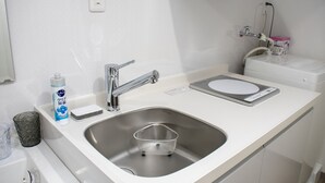 A modern bathroom with a stainless steel sink, a soap dispenser, and a toilet with a bidet attachment. - Grande Shagi GS305 (Osaka)