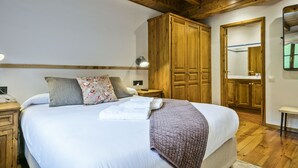 Un dormitorio con una cama grande, un armario de madera y un espejo en la pared.