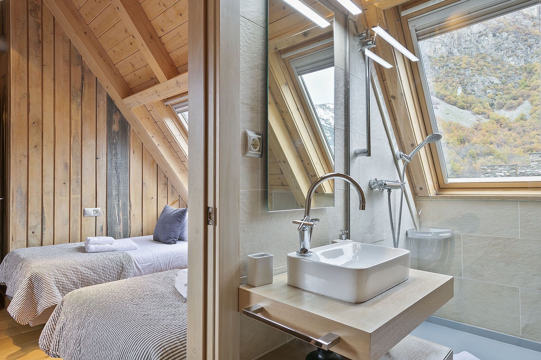 Ein modernes Badezimmer mit großem Fenster, integriertem Waschbecken und Dusche.