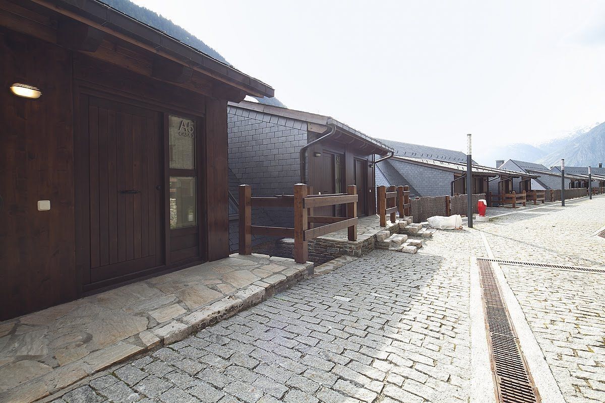 A row of wooden buildings with stone steps and a cobblestone street.