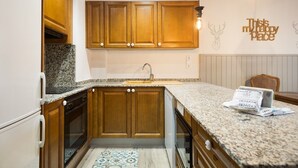 A kitchen with wooden cabinets, granite countertops, a built-in oven, and a backsplash. - Luderna - Apartamento Val de Ruda B2 Pradets (Baqueira)