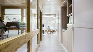 A modern interior with a wooden floor, white walls, and a dining area with chairs and a table. - Luderna - Casa Val de Ruda IV des Artiguetes (Baqueira)