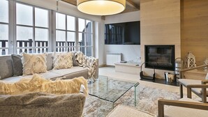 A modern living room with a sofa, glass coffee table, and a TV. - Luderna - Casa Val de Ruda IV des Artiguetes (Baqueira)