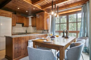 Eine Küche mit Holzausstattung, einer Arbeitsplatte aus Granit und einem Essbereich mit Holztisch und vier Stühlen.