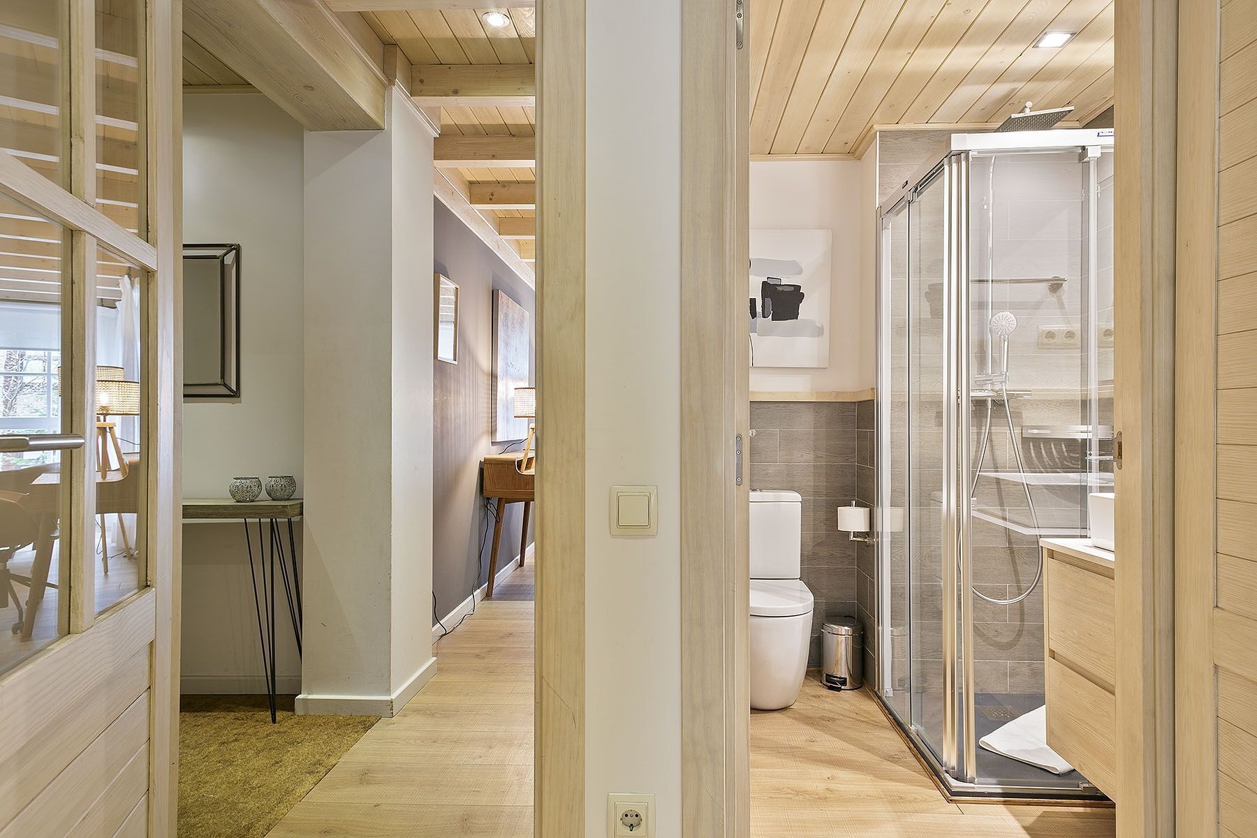 Un baño moderno con cabina de ducha de vidrio, inodoro y lavamanos.