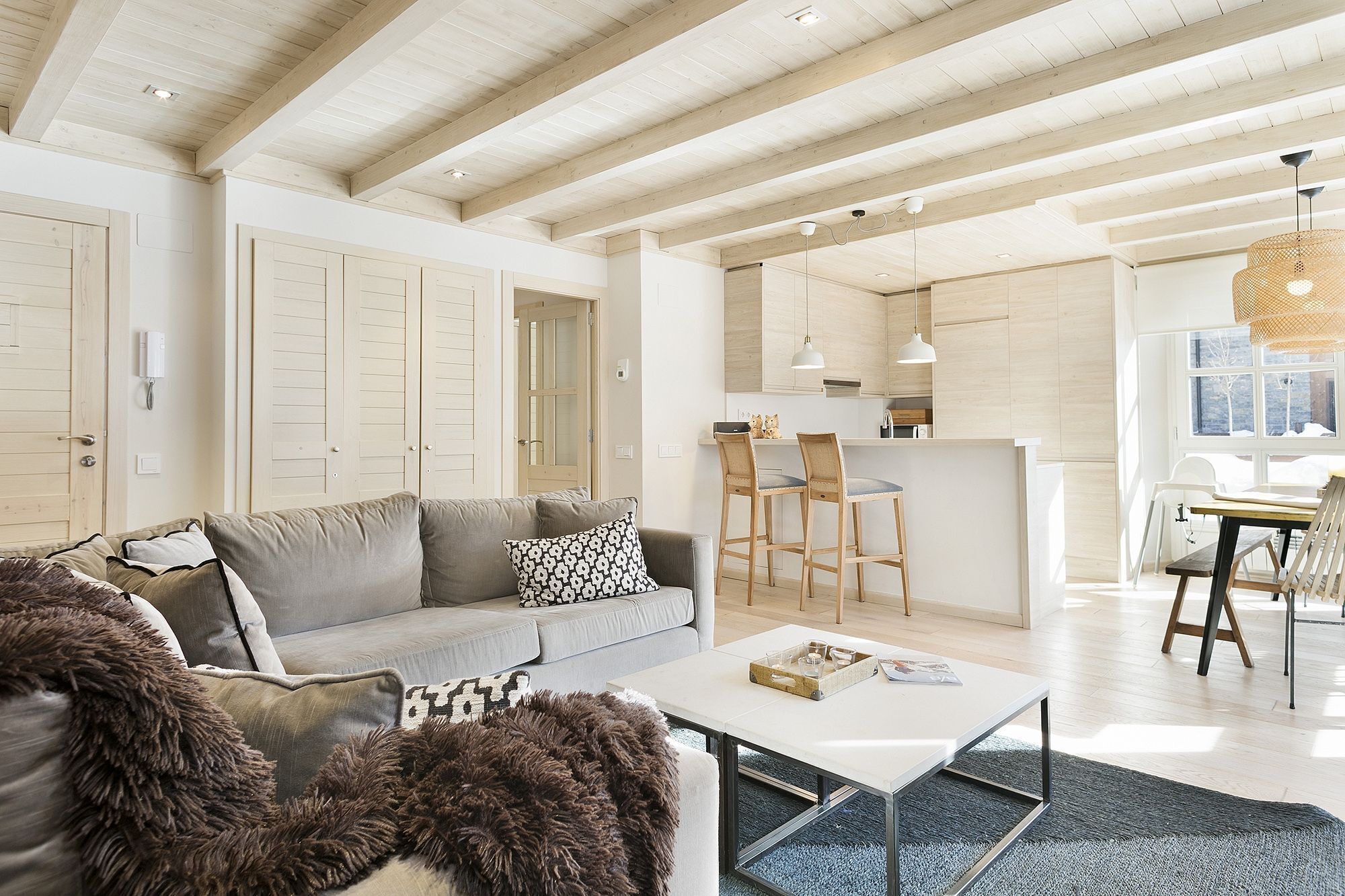 A spacious living area with a sofa, coffee table, and a view into the kitchen.