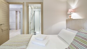 A hotel room with a bed, a bedside lamp, and a view of the bathroom.