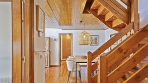 Eine Holztreppe führt zu einem Essbereich mit Tisch und Stühlen.