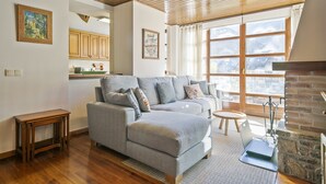Ein Wohnzimmer mit grauem Sofa, einem kleinen Holztisch und einem Kamin.