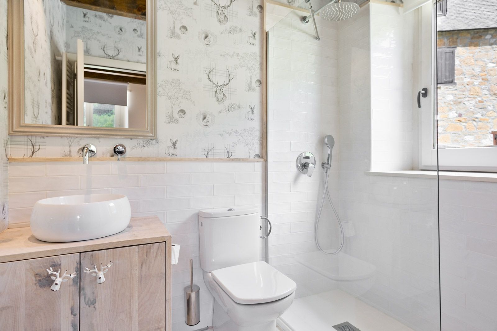 A modern bathroom with a white sink, toilet, and shower.