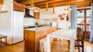 Una cocina moderna con vigas de madera, encimeras de granito y una isla central.