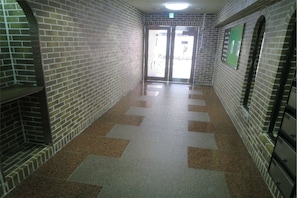 Corridors lead to double doors at the end of this interior space.
