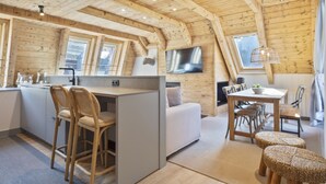 A cozy cabin interior with a kitchen area, dining space, and seating. - Luderna - Val de Ruda C23 Barbacans (Baqueira)