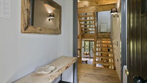Un escalier en bois mène à une mezzanine d’où l’on peut admirer la vue sur l’extérieur.