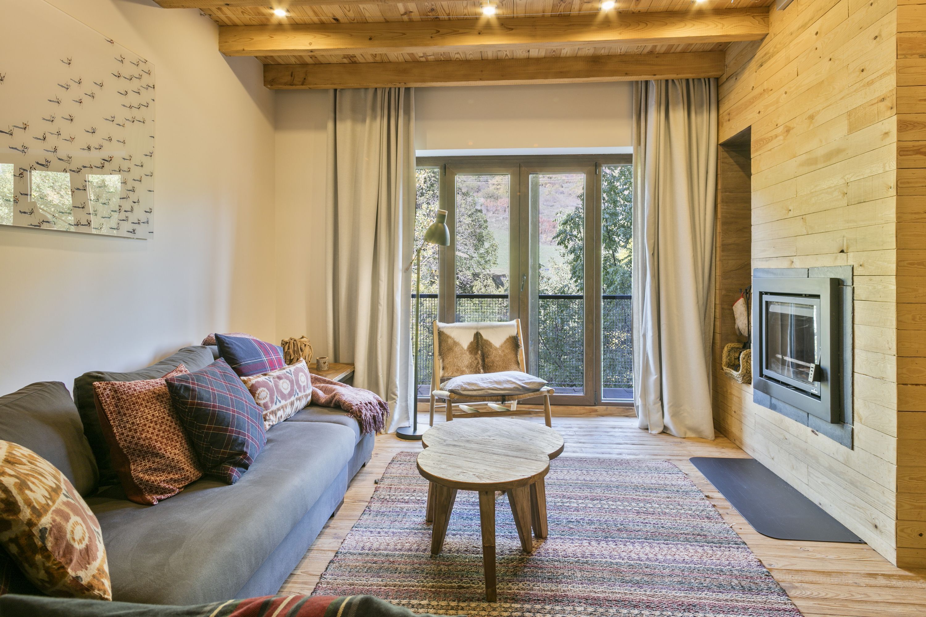 Een gezellige woonkamer met een bank, een houten tafel en een open haard.