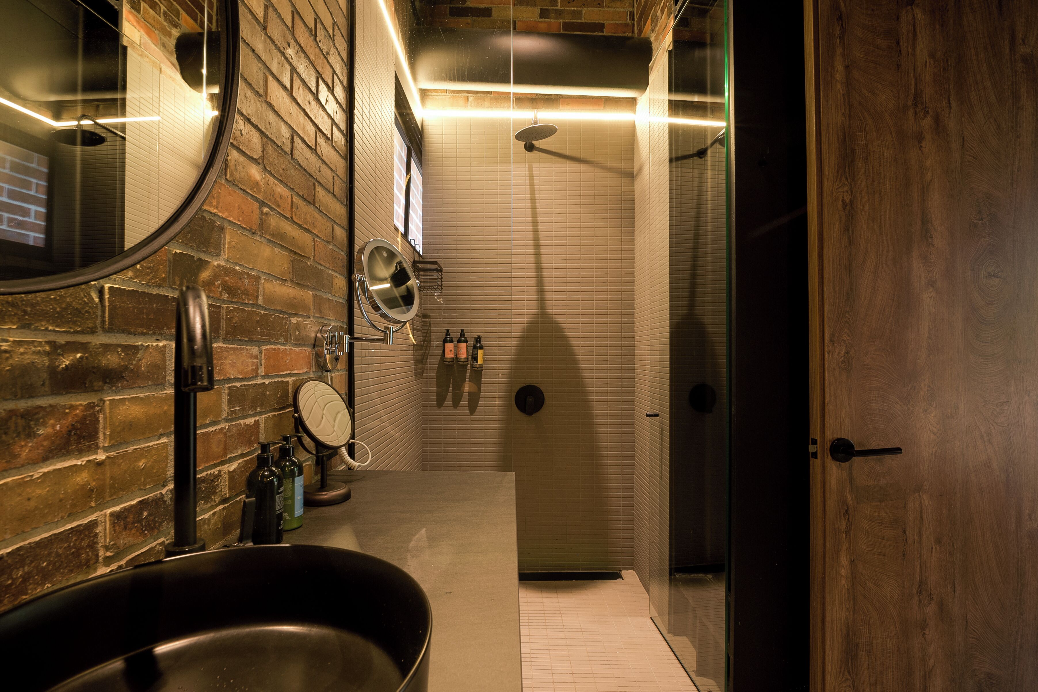 Un bany modern amb un mirall gran, un lavabo i una zona de dutxa.