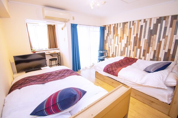 A hotel room with two beds, a TV, a desk, and a window with curtains. - Grande Shagi GS604 (Osaka)