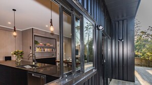 Une cuisine moderne dotée d’un grand îlot central, de bibliothèques intégrées et de luminaires suspendus.